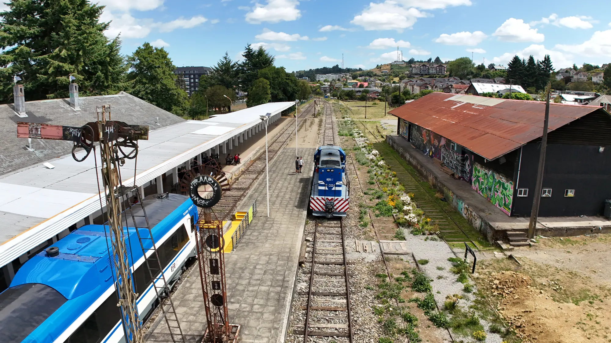 Vista elevada de la estación con el semáforo ferroviario y trenes en el andén