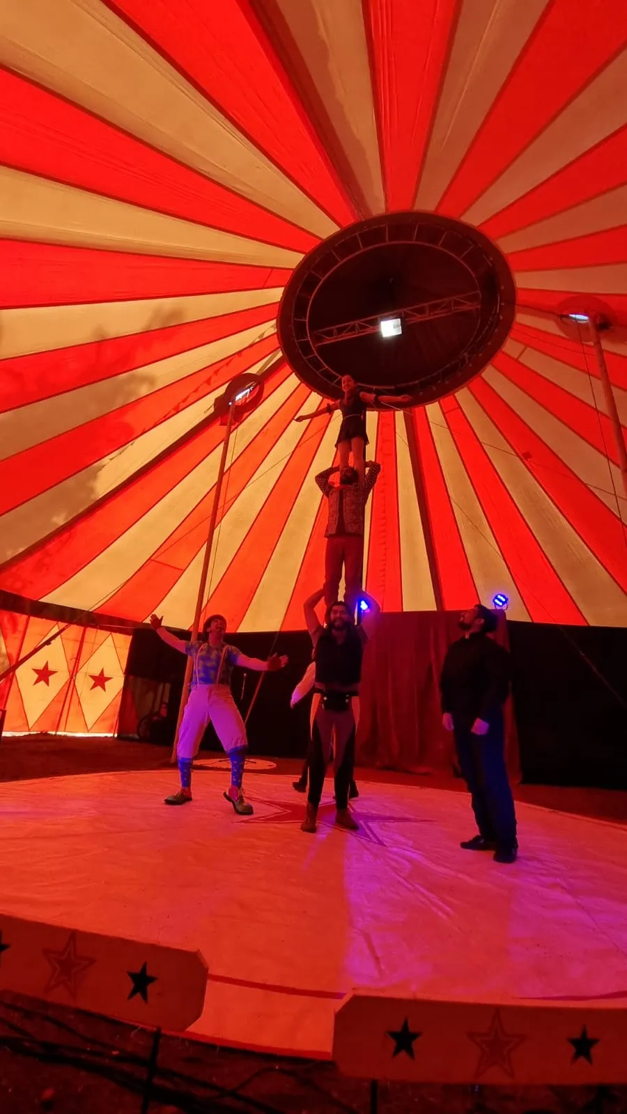 Función de Circo Estación, de la Compañía Maroma, bajo una carpa roja y amarilla en el galpón