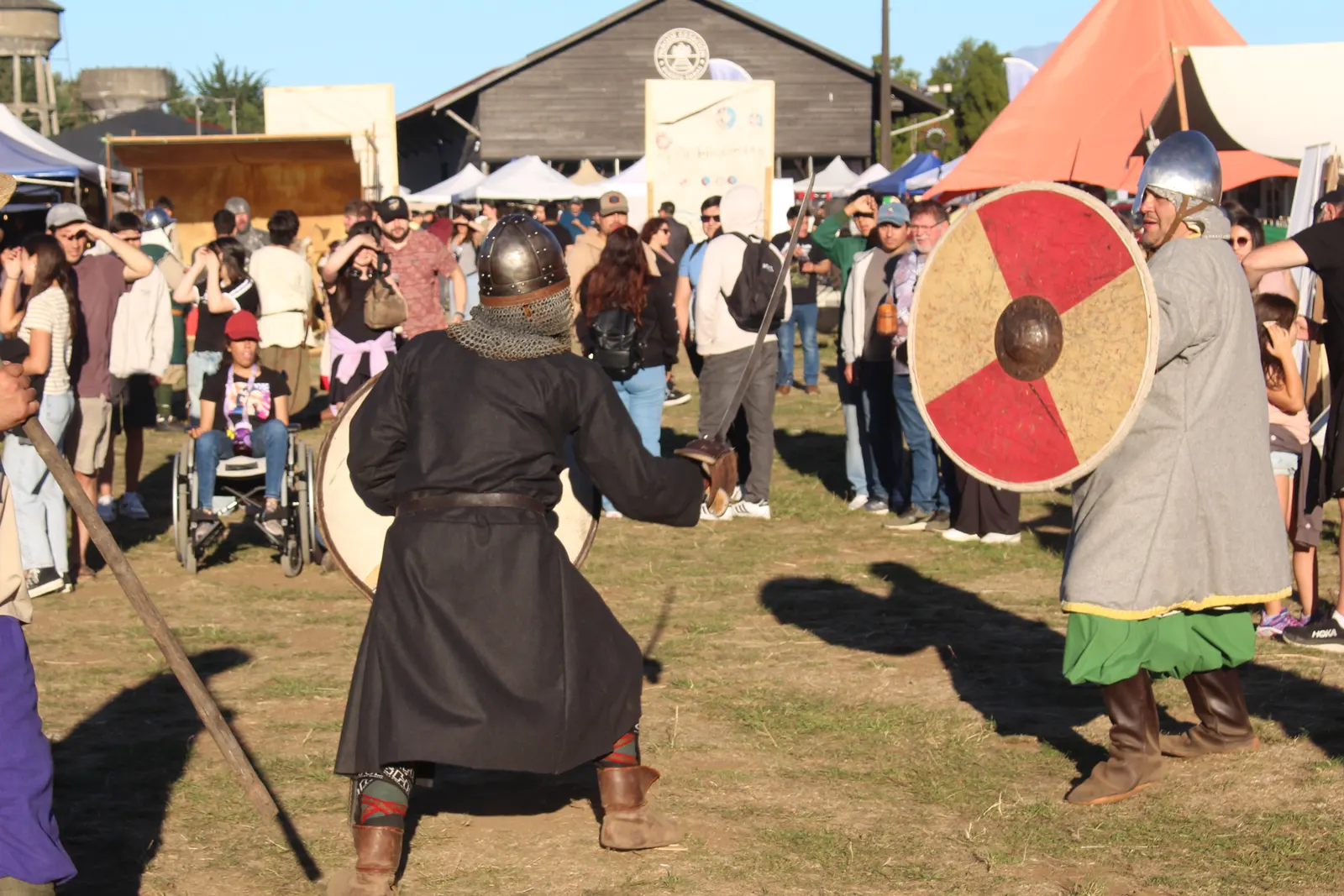 Combate medieval con escudo y casco frente al público en Feudo Medieval