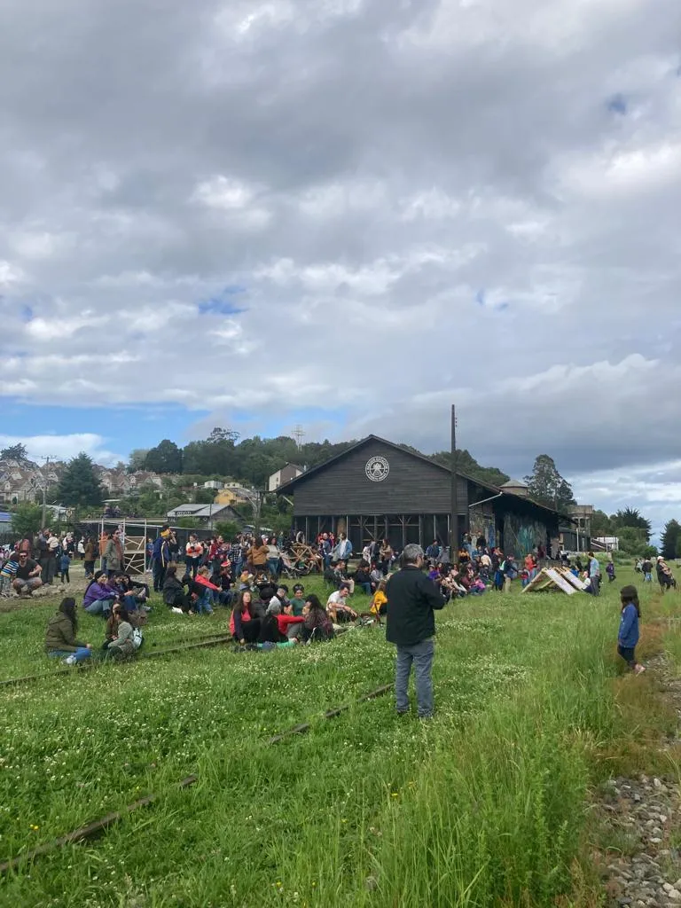 Público en el pasto frente al galpón durante el Carnaval del Sur